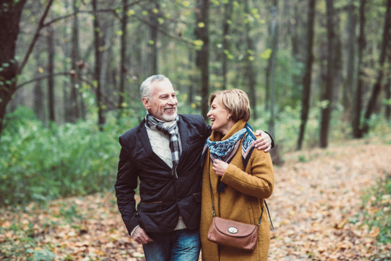 Healthy Aging After 50: Daily Habits to Boost Energy and Joy Happy mature couple walking in park holding hands.