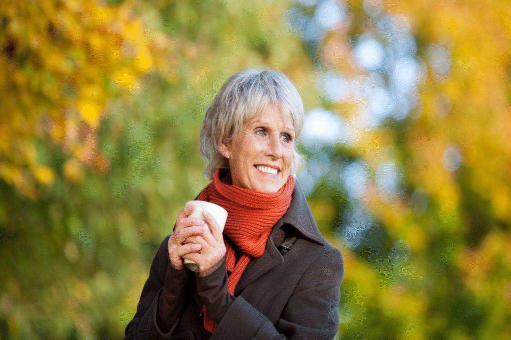Smiling mature woman enjoying coffee and sunshine.