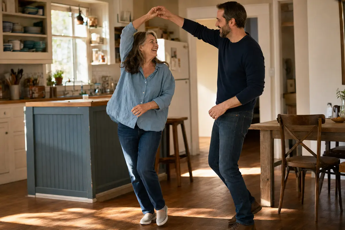 Woman in her 60s comfortably dancing with her adult son at home