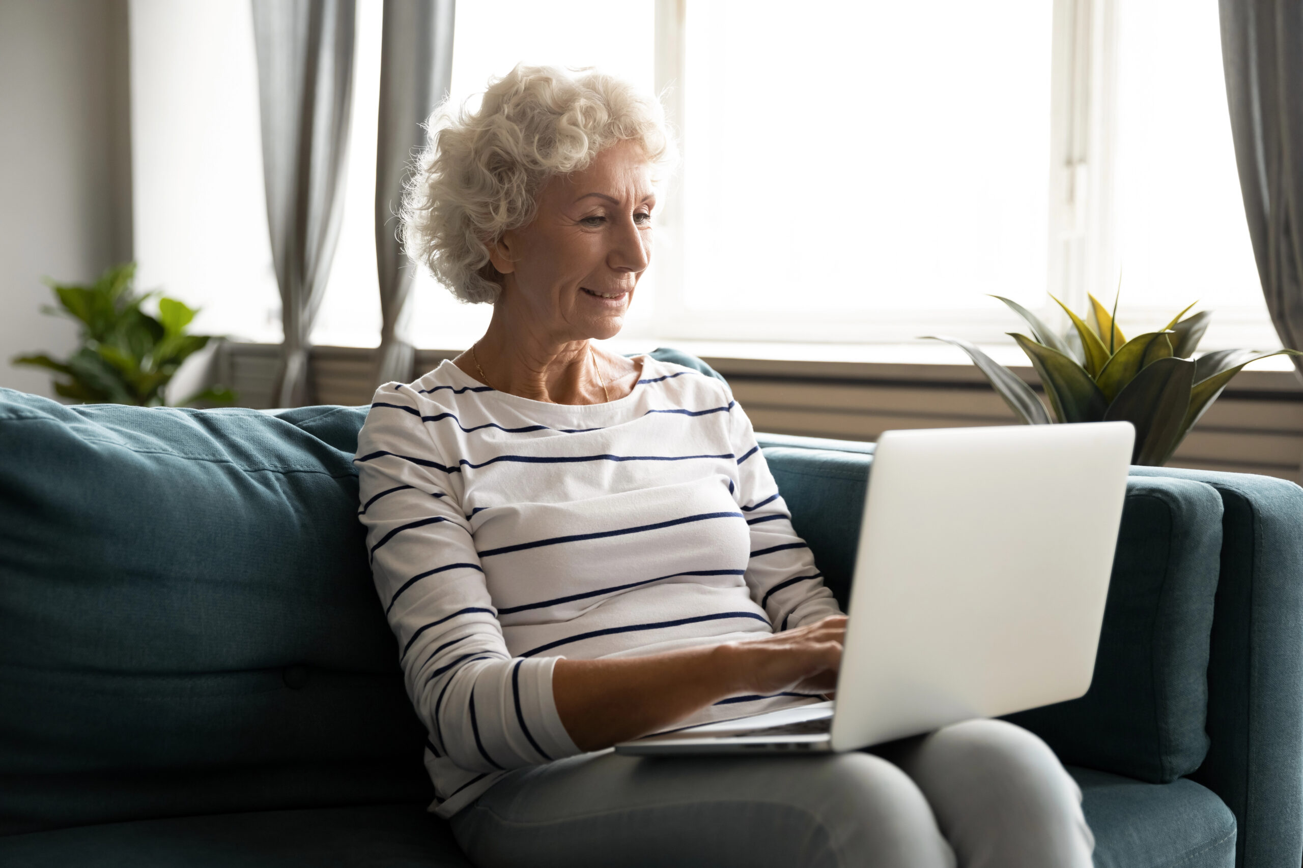 senior woman looking hopeful on laptop