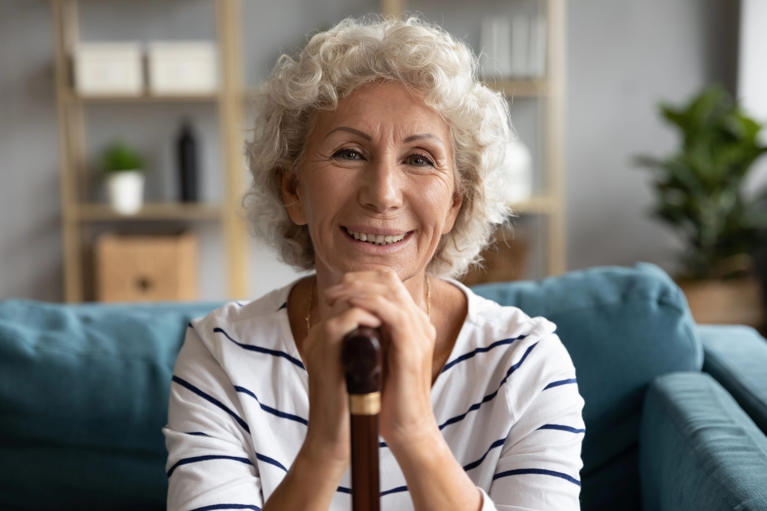 Senior woman with cane but a smile on her face as she feels better