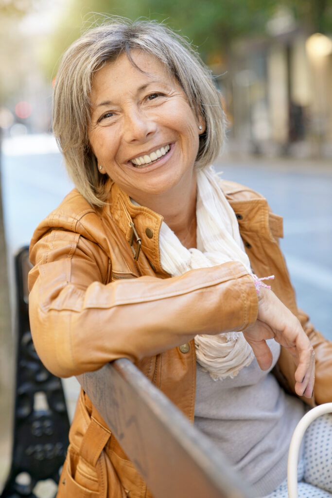Healthy and active senior woman smiling in the park happy without age anxiety