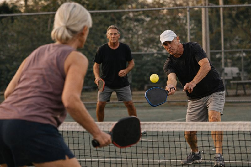 active adults over 50 happily playing pickleball