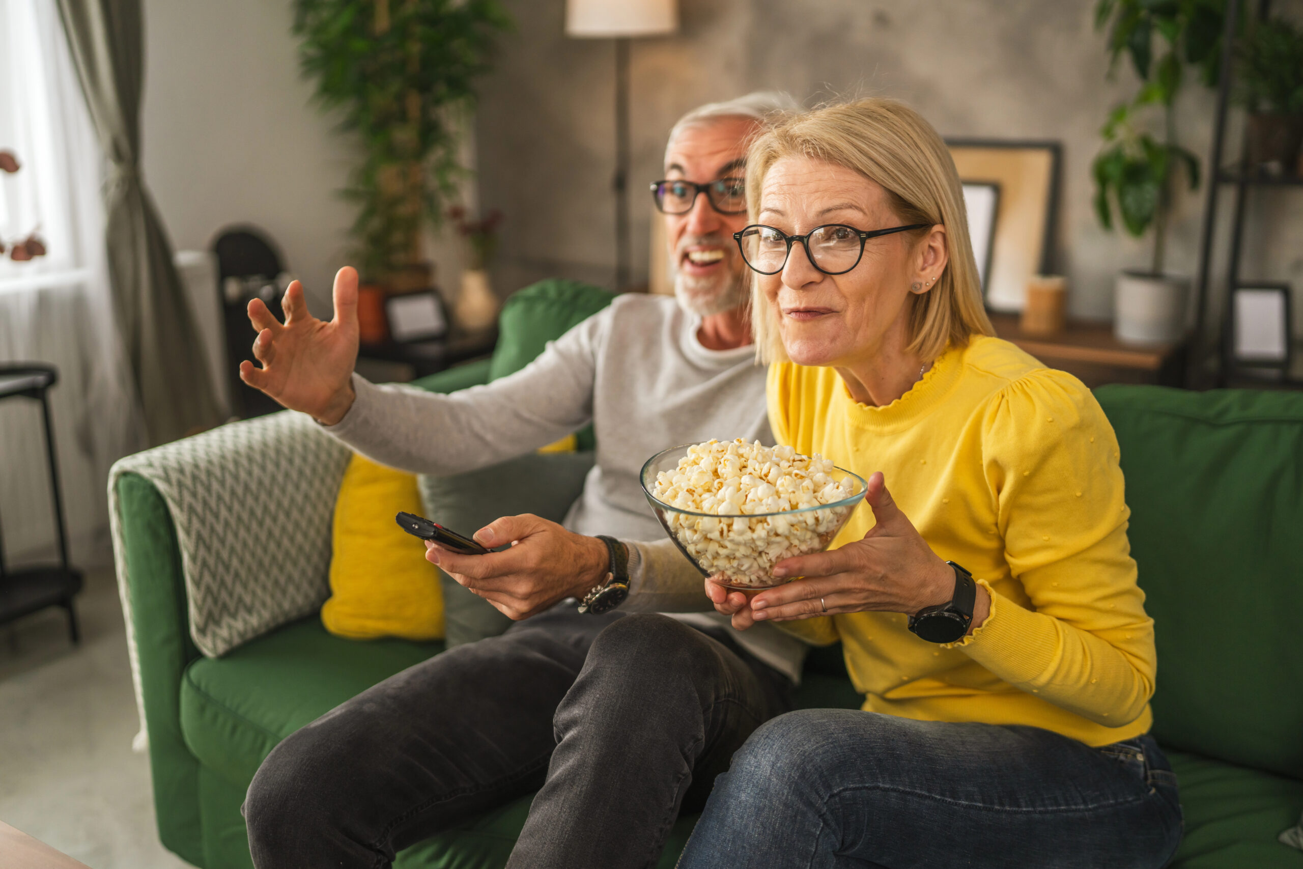 mature man and woman watching a movie and discussing being curious